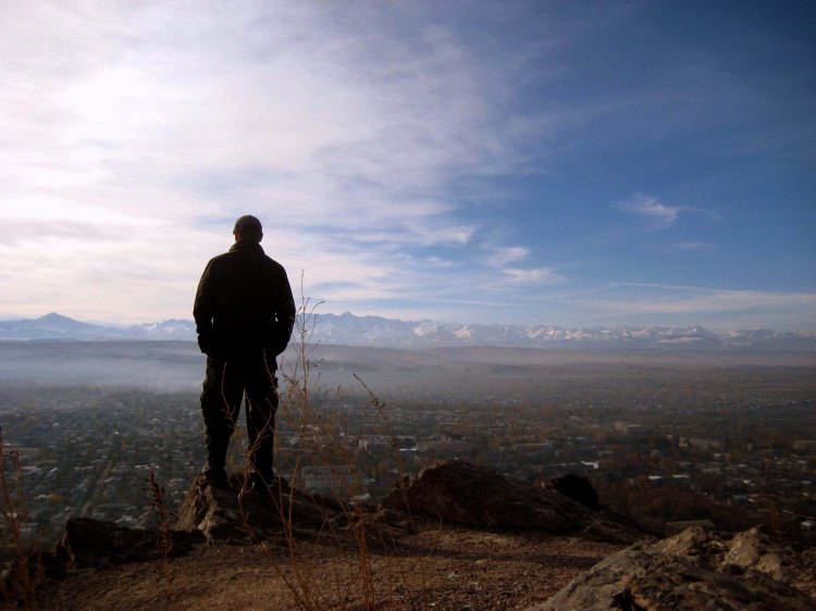 Man on top of Mt. Solomon looking at Osh